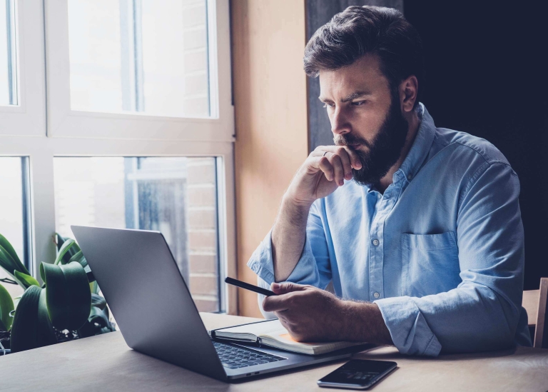 Chasseur immobilier mandataire indépendant qui travail sur ordinateur portable.