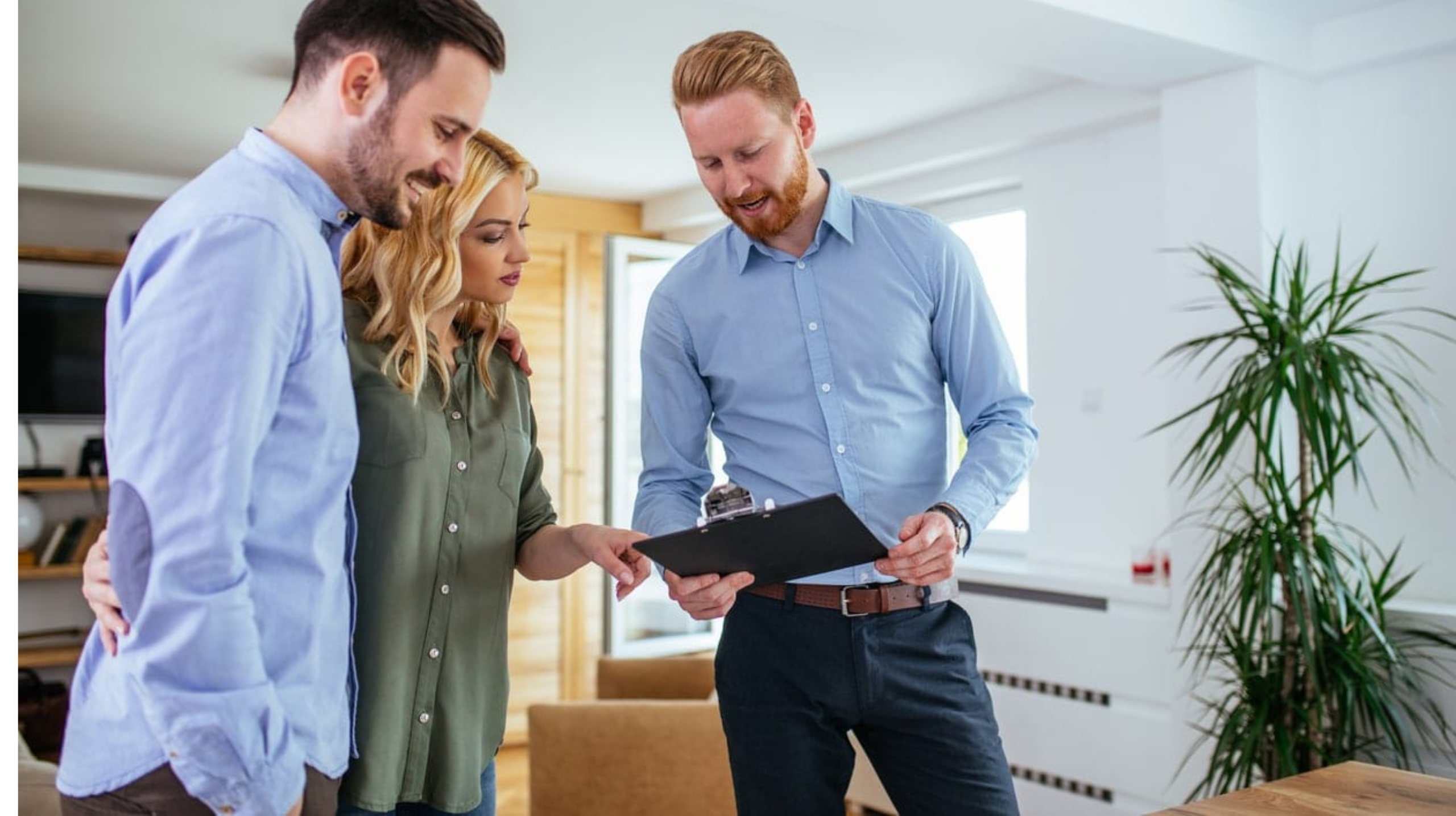Agent immobilier présentant un bien à un couple.